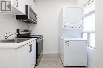 Toronto (South Riverdale) apartment for rent - A white kitchen with a dishwasher and a microwave.