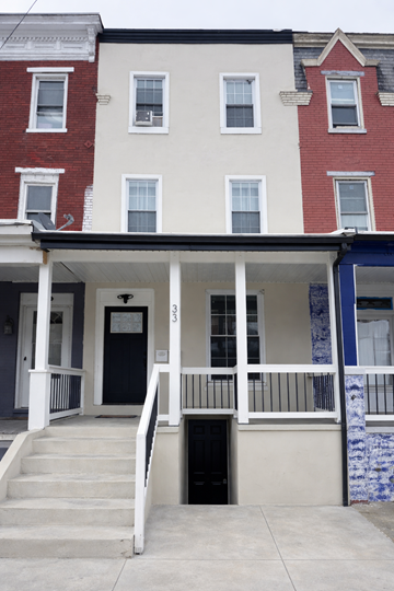 Harrisburg apartment for rent - A two story building with a black door and white railings.