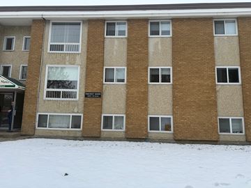 Edmonton apartment for rent - The building is made of brown bricks and has a sign that reads "Marshall.".