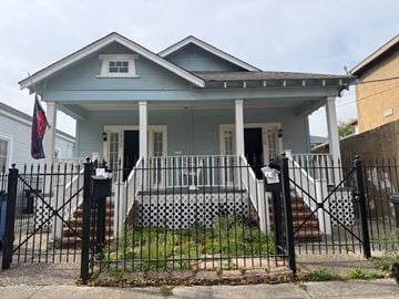 New Orleans apartment for rent - A blue house with a black gate in front.