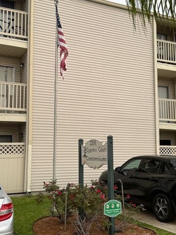 Metairie apartment for rent - A sign in front of a building that says "1300 Congress Court" and has a flag on top.