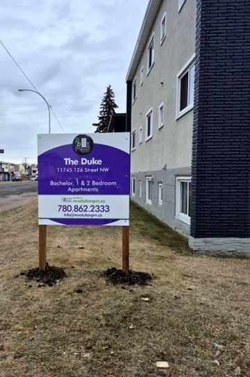 Edmonton apartment for rent - A sign for The Duke apartment complex is in front of a building.