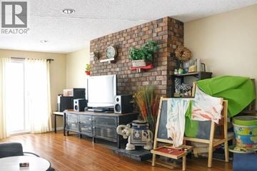 Burnaby duplex for rent - A living room with a brick fireplace and a flat screen TV.