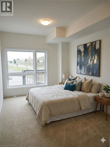 Kitchener townhouse for rent - A bedroom with a large bed and a painting on the wall.
