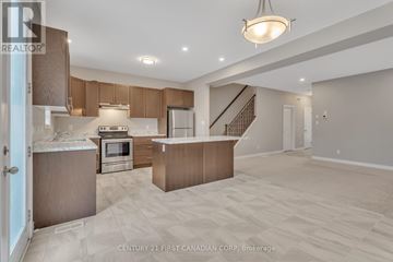 London North (North D) apartment for rent - A spacious kitchen and living room with wooden cabinets and a staircase.