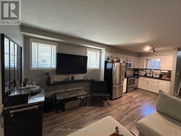London South (South W) townhouse for rent - A living room with a black couch and a television.
