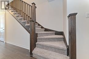 Cambridge townhouse for rent - A staircase with a wooden handrail and beige carpeted steps.