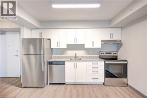 Kitchener condo for rent - A kitchen with white cabinets and stainless steel appliances.