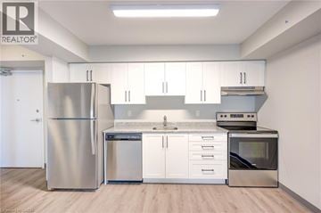 Kitchener condo for rent - A kitchen with white cabinets and stainless steel appliances.