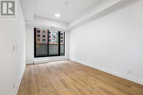 Toronto (Thorncliffe Park) condo for rent - A room with a large window and wooden flooring.