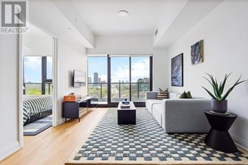 Toronto (Thorncliffe Park) condo for rent - A living room with a grey couch and a black and white rug.