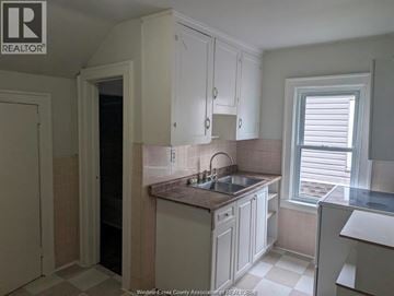 Windsor apartment for rent - A kitchen with white cabinets and a tiled backsplash.