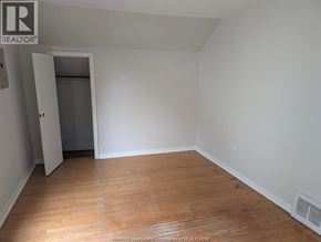 Windsor duplex for rent - A room with wooden floors and white walls, with a doorway leading to another room.
