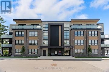 South Huron (Exeter) multi-family for rent - A modern building with a glass entrance and a sign that reads "15 James St." in front of it.