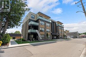 South Huron (Exeter) multi-family for rent - A modern multi-story building with a glass entrance and balcony.