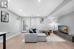 Toronto (Oakridge) apartment for rent - A modern living room with a grey sofa and a flat screen TV.