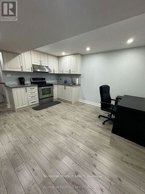 Toronto (Morningside) apartment for rent - A kitchen with a black counter and a black chair.