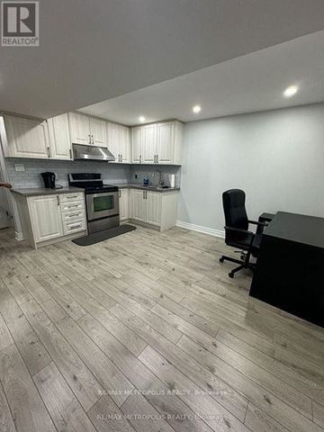 Toronto (Morningside) apartment for rent - A kitchen with a black counter and a black chair.