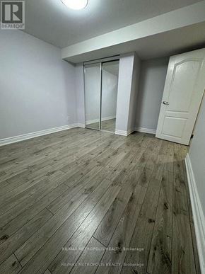 Toronto (Morningside) apartment for rent - A room with wooden flooring and white walls, with a door on the right and a sliding door on the left.