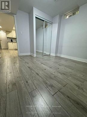 Toronto (Morningside) apartment for rent - A room with wooden flooring and a glass door.