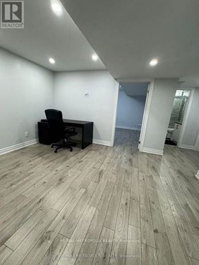 Toronto (Morningside) apartment for rent - A room with a wooden floor and a black office chair.
