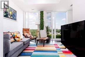 Toronto (Birchcliffe-Cliffside) condo for rent - A living room with a grey couch, a wooden coffee table, a flat screen TV and a colorful rug.