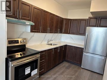 Toronto (Ionview) condo for rent - A kitchen with dark wood cabinets and stainless steel appliances.