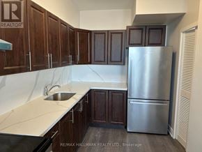 Toronto (Ionview) condo for rent - A kitchen with wooden cabinets and a stainless steel refrigerator.
