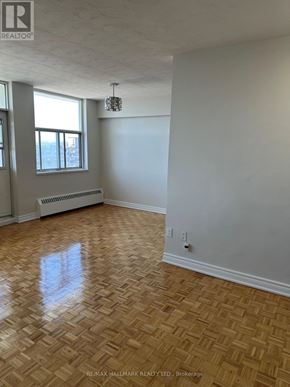 Toronto (Ionview) condo for rent - A room with a wooden floor and a window with a radiator beneath it.
