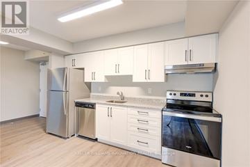 Kitchener condo for rent - A kitchen with white cabinets and stainless steel appliances.