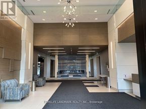 Markham (Unionville) condo for rent - A lobby area with a black and white carpet, a chandelier, and a reception desk.