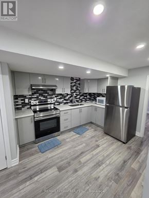 Brampton (Northwest Brampton) apartment for rent - A modern kitchen with a stainless steel refrigerator and wooden flooring.
