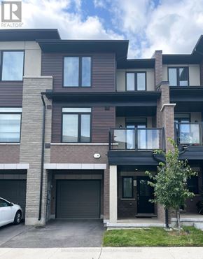 Hamilton (Lakeshore) townhouse for rent - A modern two-story residential building with a white car parked in front.