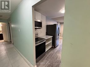 Kitchener condo for rent - A kitchen with a stove top oven and a refrigerator.