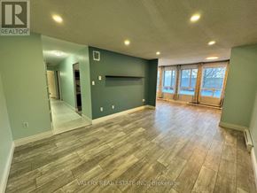 Kitchener condo for rent - A room with wood flooring and a wall with a window.