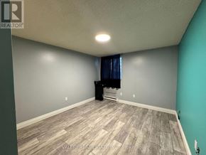 Kitchener condo for rent - A room with a grey wall and a wooden floor.