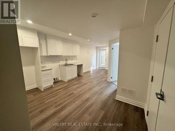 Niagara Falls (Brown) townhouse for rent - A kitchen with white cabinets and a wooden floor.