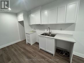 Niagara Falls (Brown) townhouse for rent - A kitchen with white cabinets and a sink.