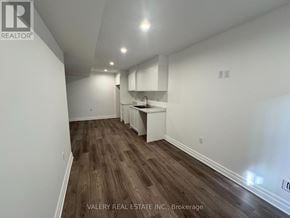 Niagara Falls (Brown) townhouse for rent - A room with wooden flooring and white walls, with a kitchenette in the corner.