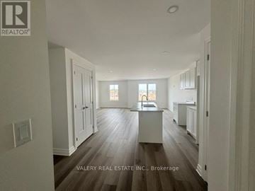 Niagara Falls (Brown) townhouse for rent - A spacious kitchen with wood flooring and white cabinetry.