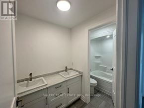Niagara Falls (Brown) townhouse for rent - A bathroom with a sink, toilet, and bathtub.