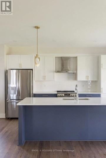 Ottawa apartment for rent - A kitchen with a stainless steel refrigerator and a sink with a countertop.