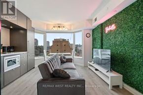 Toronto (Annex) condo for rent - A modern living room with a green wall and a flat screen TV.