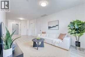 Lasalle condo for rent - A living room with a white couch, a coffee table, and a plant.