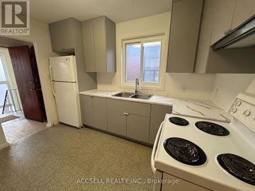 Toronto (Humewood-Cedarvale) triplex for rent - A kitchen with a white stove top oven and a white refrigerator.