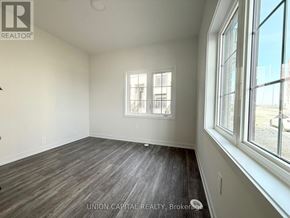 Richmond Hill (Headford Business Park) townhouse for rent - A room with wooden flooring and a window with a view of a parking lot.