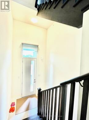 Markham (Victoria Square) townhouse for rent - A hallway with a black railing and a window.