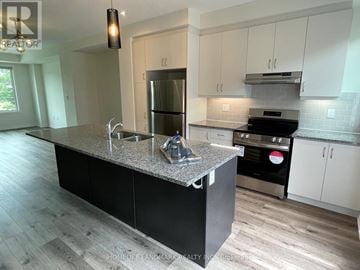 Markham (Victoria Square) townhouse for rent - A kitchen with a granite countertop and stainless steel appliances.