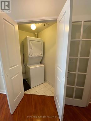 Mississauga (City Centre) condo for rent - A white toilet is in a small room with a door open to a hallway.