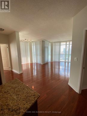 Mississauga (City Centre) condo for rent - A large empty room with wooden floors and a marble countertop.